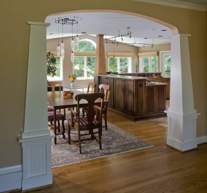 WIDENED OPENING TO DINING AREA REPEATS COLUMN AND ARCH DETAIL FROM ENTRY.