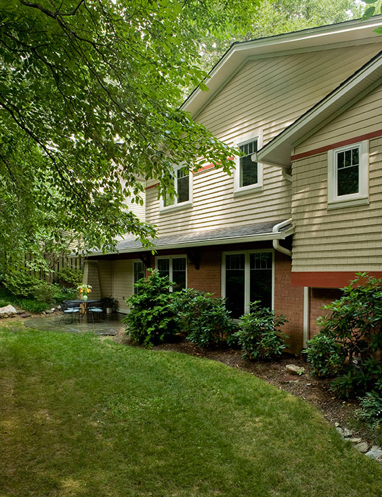 REAR ELEVATION WITH PATIO OFF NEW MUDROOM, SECOND STORY ADDITION.