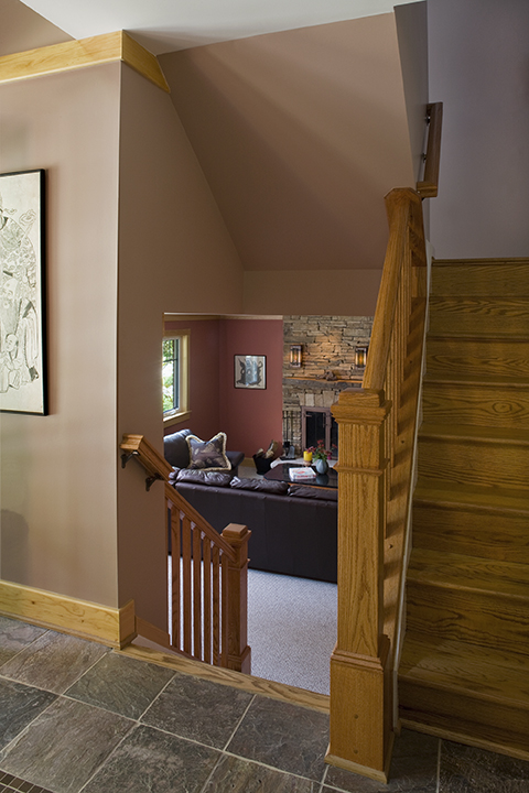 LOWER LEVEL BECOMES PART OF LIVING SPACE BY REMOVING WALL BETWEEN STAIR FLIGHTS.